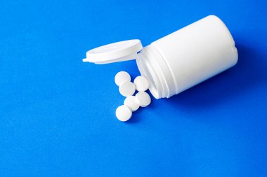 Haplar mavi arka planda şişeden döküldü. Yüksek kalite fotoğraf