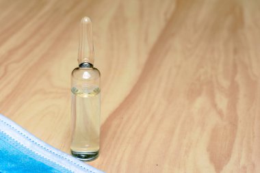 Tıbbi maske ve ampul. Masada ilaç var. Yüksek kalite fotoğraf