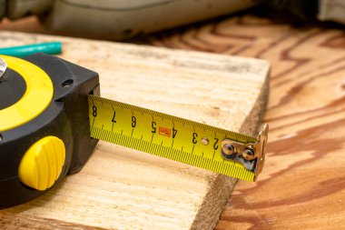 Ahşap bir tahtanın üzerindeki mezura. Yüksek kalite fotoğraf