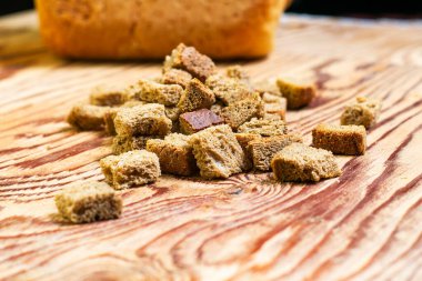 Arka plandaki ahşap masada çavdar krakerleri bulanık bir somun ekmek. Yüksek kalite fotoğraf