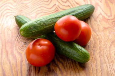 Tahta bir yüzeyde iki salatalık ve üç domates. Yüksek kalite fotoğraf