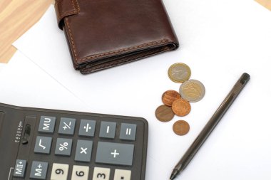 Masa konsepti iş bütçesi ekonomisinde küçük madeni paralar cüzdan hesap makinesi ve beyaz kağıt sayfaları üzerinde dolmakalem. Yüksek kalite fotoğraf