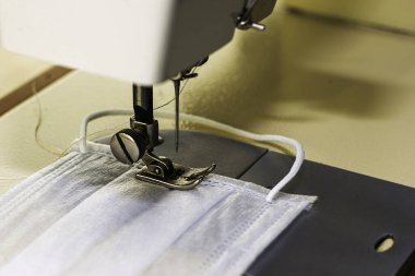 Dikiş makinesi koruyucu tıbbi maske dikiyor. Yüksek kalite fotoğraf