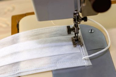 Dikiş makinesi koruyucu tıbbi maske dikiyor. Yüksek kalite fotoğraf