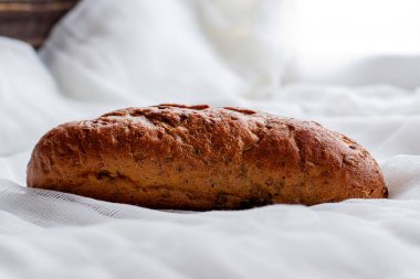 Çavdar ekmeği, beyaz bir peçetenin üzerinde yeni pişmiş. Yüksek kalite fotoğraf