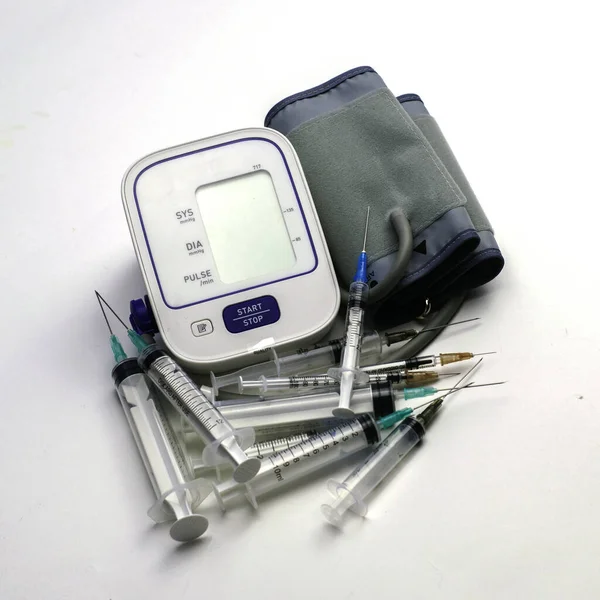 Un monitor de presión arterial y muchas jeringas a su alrededor — Foto de Stock