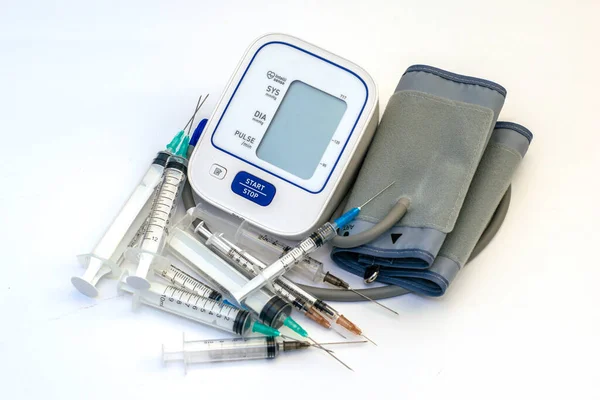 Ein Blutdruckmessgerät und viele Spritzen drumherum — Stockfoto