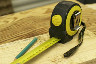 Ahşap bir tahtanın üzerindeki mezura. Yüksek kalite fotoğraf