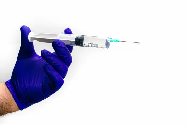 一只手戴着蓝色的医疗手套 手里拿着注射器的液体从注射器的针头流出 高质量的照片 — 图库照片