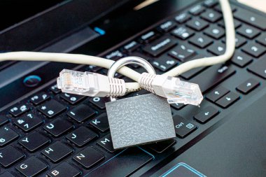 İnternet kablosu bilgisayardaki bir klavye veri koruma kavramının kapalı demir kilidinden geçiyor. Yüksek kalite fotoğraf