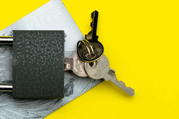 padlock with keys on a credit card on a yellow background data protection concept deposit protection. High quality photo