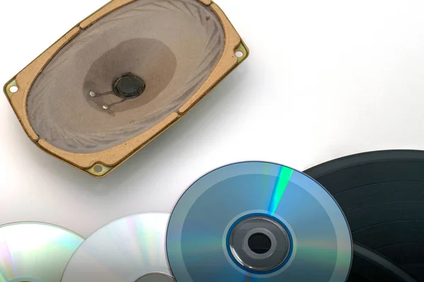 CDs e discos de vinil ao lado do alto-falante em um conceito de tecnologia de gravação de som de fundo branco — Fotografia de Stock