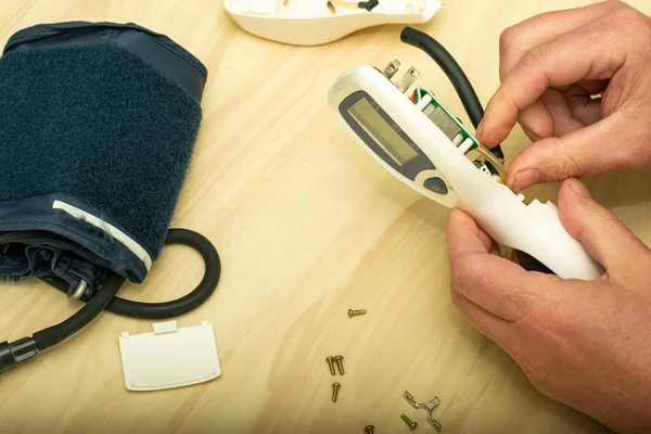 Der Meister Repariert Das Elektronische Tonometer Und Steckt Eine Gummilampe — Stockfoto