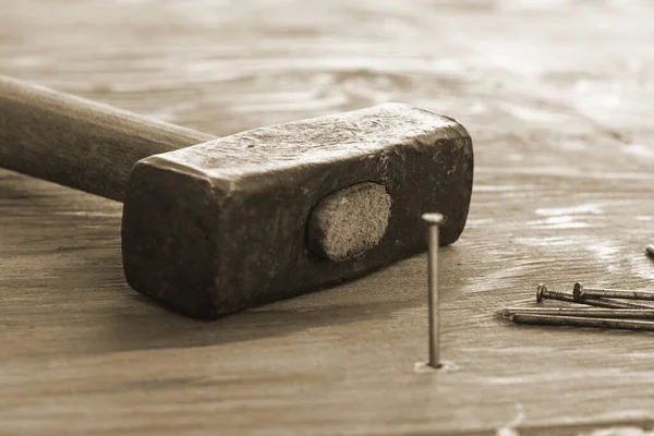 hammer and nails on the wooden surface one nail is hammered into the board. High quality photo