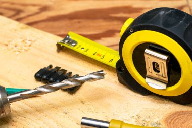 Tahta bir tezgahta matkap kalem tornavidayla mezura ölçüsü ölçüyorum. Yüksek kalite fotoğraf