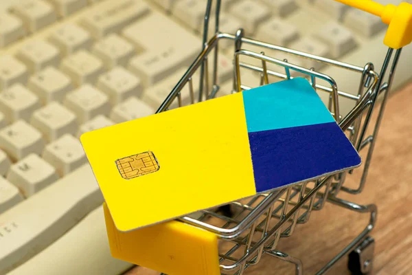 shopping cart with a credit card on the background of a computer keyboard concept internet business online banking. High quality photo
