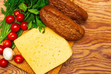 Bir parça peynir, kiraz, domates, mantar ve çavdar ekmeği.