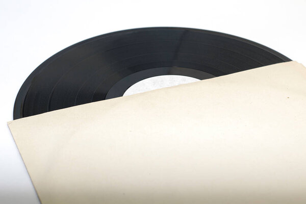 an old vinyl record in a paper envelope on a white background