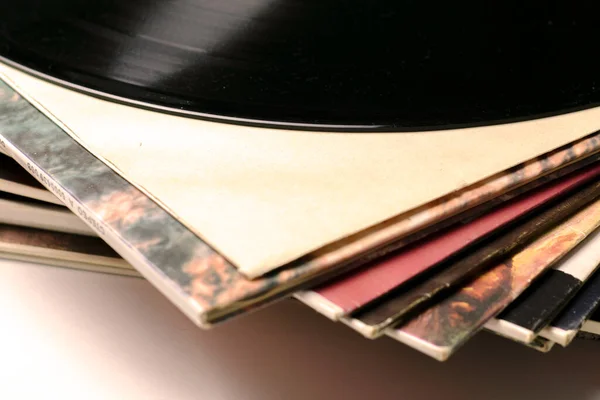 Una pila de viejos discos de vinilo cerrar uno de los registros se saca del sobre — Foto de Stock