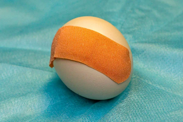 chicken egg with a medical patch pasted on a medical napkin concept vaccination medicine. High quality photo
