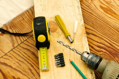 Tahta bir tezgahta matkap kalem tornavidayla mezura ölçüsü ölçüyorum. Yüksek kalite fotoğraf