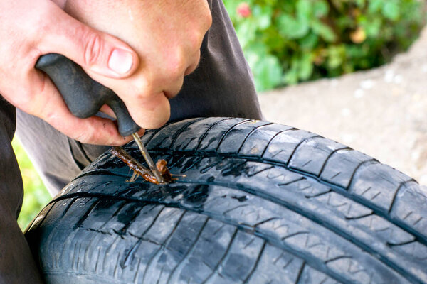 Вулканизатор восстанавливает прокол шины вставляет уплотнительный шнур в отверстие. Высокое качество фото