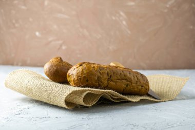 Gri arka planda çuval bezli iki taze çavdar ekmeği. Yüksek kalite fotoğraf