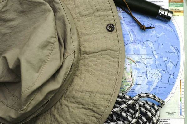 世界の地理地図上の観光旅行の概念には帽子登山ロープとペンナイフがあります — ストック写真