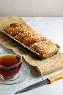 Kirazlı vanilyalı bisküvi bıçağı ve açık gri yüzeyde bir fincan çay. Yüksek kalite fotoğraf