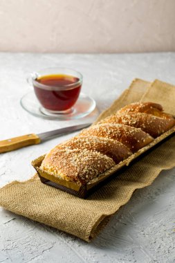 Kirazlı vanilyalı bisküvi bıçağı ve açık gri yüzeyde bir fincan çay. Yüksek kalite fotoğraf