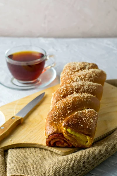 Kirazlı vanilyalı bisküvi bıçağı ve açık gri yüzeyde bir fincan çay. Yüksek kalite fotoğraf