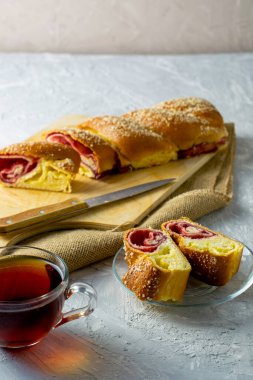 Kirazlı vanilyalı turta için bir bıçak ve açık gri bir yüzeyde bir fincan çay. İki parça turta bir tabağın üzerinde. Yüksek kalite fotoğraf