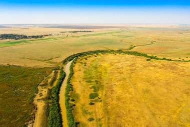Bozkırda akan bir nehrin kıvrımlı manzarası bir dron tarafından çekiliyor. Yüksek kalite fotoğraf