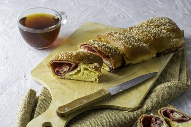 Kirazlı vanilyalı turta için bir bıçak ve açık gri bir yüzeyde bir fincan çay. İki parça turta bir tabağın üzerinde. Yüksek kalite fotoğraf