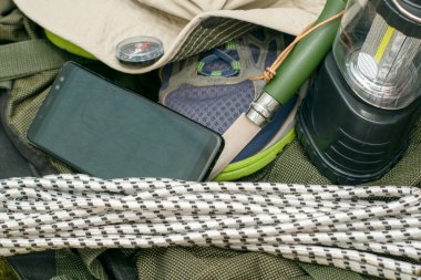 Sırt çantalı spor ayakkabılar pusula, pusula, katlanabilir çadır feneri ve açık harita seyahat konsepti turizmi içeren akıllı telefon. Yüksek kalite fotoğraf