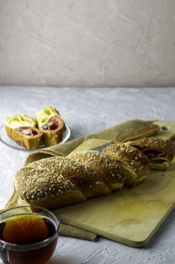 Kirazlı vanilyalı turta için bir bıçak ve açık gri bir yüzeyde bir fincan çay. İki parça turta bir tabağın üzerinde. Yüksek kalite fotoğraf