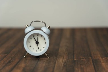 Saat 5 ile 12 arası küçük beyaz çalar saat.