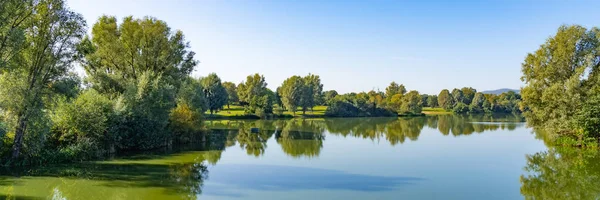 Almanya 'nın Kassel kentindeki Fuldaaue' de bir yaz günü göl manzarasının güzel bir manzarası.