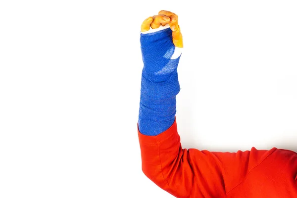 身穿红色毛衣的妇女用新操作的手握住她的胳膊 她的手带有蓝色绷带 手指呈直角 呈橙色 — 图库照片
