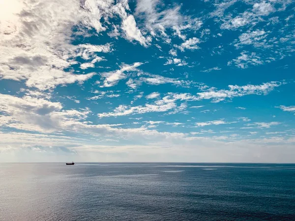 Mare calmo e cielo blu con nuvole di sfondo. — Foto Stock