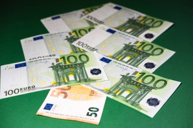 Parlak yeşil arka planda yeşil ve turuncu renkli Avrupa para birimi banknotlarından yapılmış Noel ağacı. Noel ağacı şeklinde nakit para. Bankacılık ve Finans.