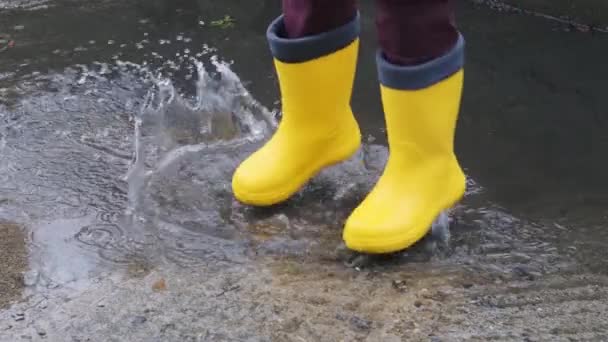 Melompat Melalui Genangan Air Sepatu Karet Kuning Berjalan Dalam Hujan — Stok Video