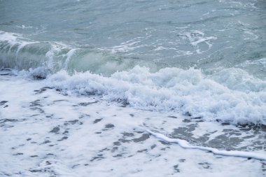 Nazikçe dalgalanan deniz ve beyaz köpüklü dalgalar. Mavi ve bazen turkuaz soğuk Kuzey Denizi. Hava serin ve temiz. Minimalist okyanus arkaplanı.