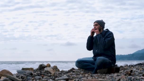 Pojke Med Skägg Kaukasiskt Utseende Sitter Klippiga Stranden Havet Mot — Stockvideo