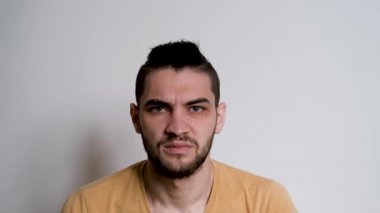 Sakallı genç beyaz adam ağzıyla tiksinti duyuyor. İnsanoğlu heyecanlı, kafası karışık ve olanlara katılmıyor, bundan hoşlanmıyor. Stüdyodaki kişinin duyguları..