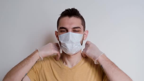 髭を生やした白人白人男性は 顔の上に白い保護医療用マスクを取り除き 真剣に前を見つめています ウイルスや細菌に対する個人的な保護 ビデオ映像4K — ストック動画