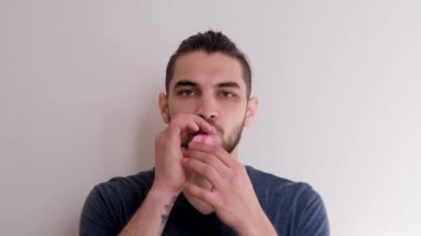 Ağzınla pembe bir balon şişir ve sonra uçup gitmesine izin ver. Sakallı, at kuyruklu, beyaz atlı, beyaz saçlı, genç, beyaz Avrupalı bir adam balonu arka planda şişiriyor..