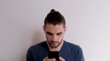 Mavi tişörtlü, tıbbi koruyucu maskeli, beyaz lateks eldivenli beyaz arka planda duran ve şırıngayı ilaçla dolduran beyaz bir beyaz öğrenci. Adam iğneyi yapacak..