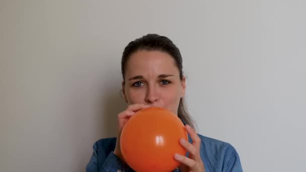 Hezká Žena Kavkazského Evropského Vzhledu Nafoukne Oranžový Balón Ústy Bílém — Stock video