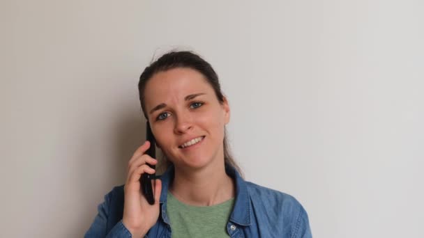 Молодая Европейка Рубашке Белом Фоне Звонит Мобильному Телефону Радостно Улыбается — стоковое видео